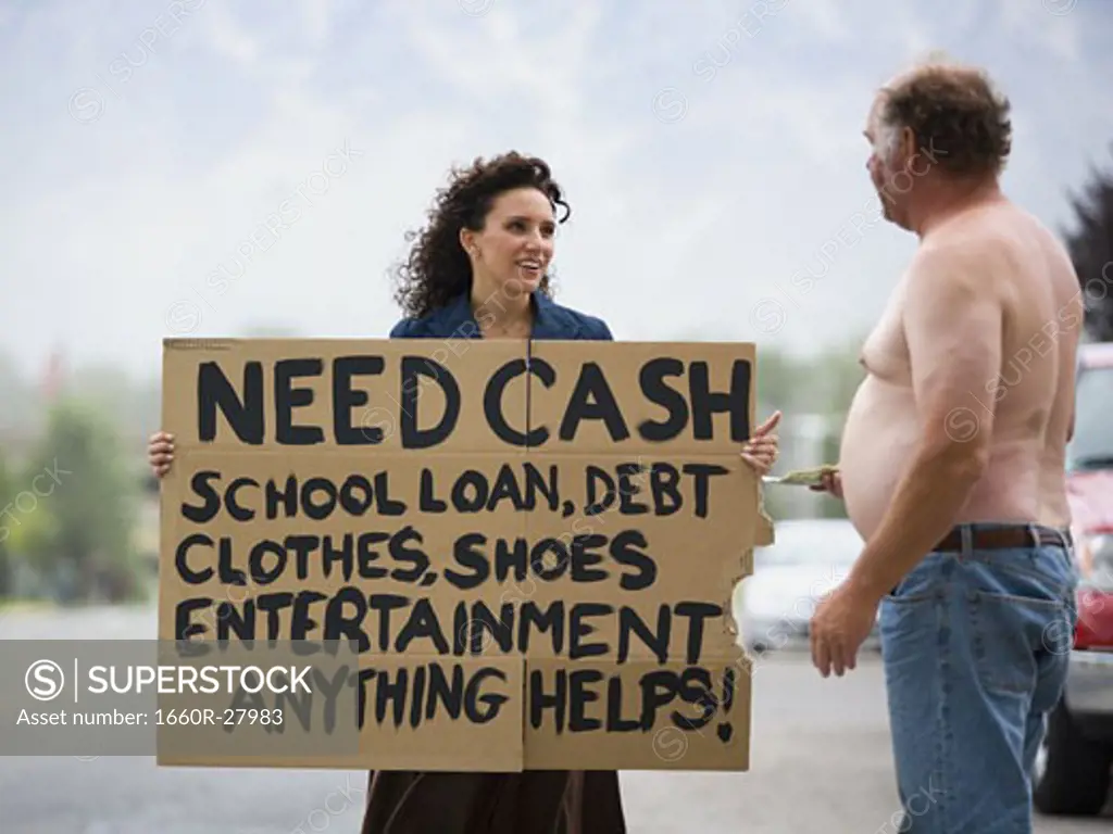 Young woman holding a help-needed sign and looking at a man