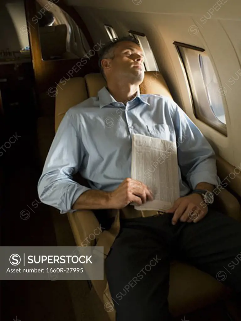 A businessman sleeping in an airplane