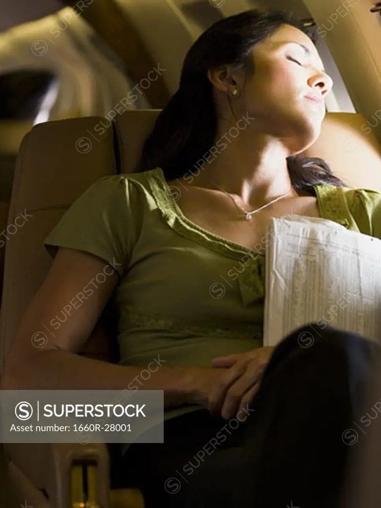 A businesswoman sleeping in an airplane