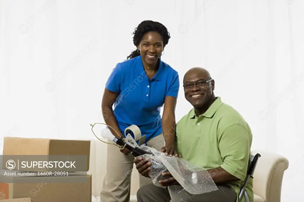Portrait of a senior couple smiling and packing up a lamp