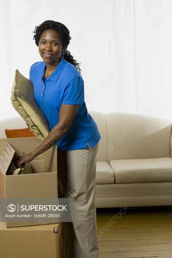 Portrait of a senior woman unpacking a cardboard box