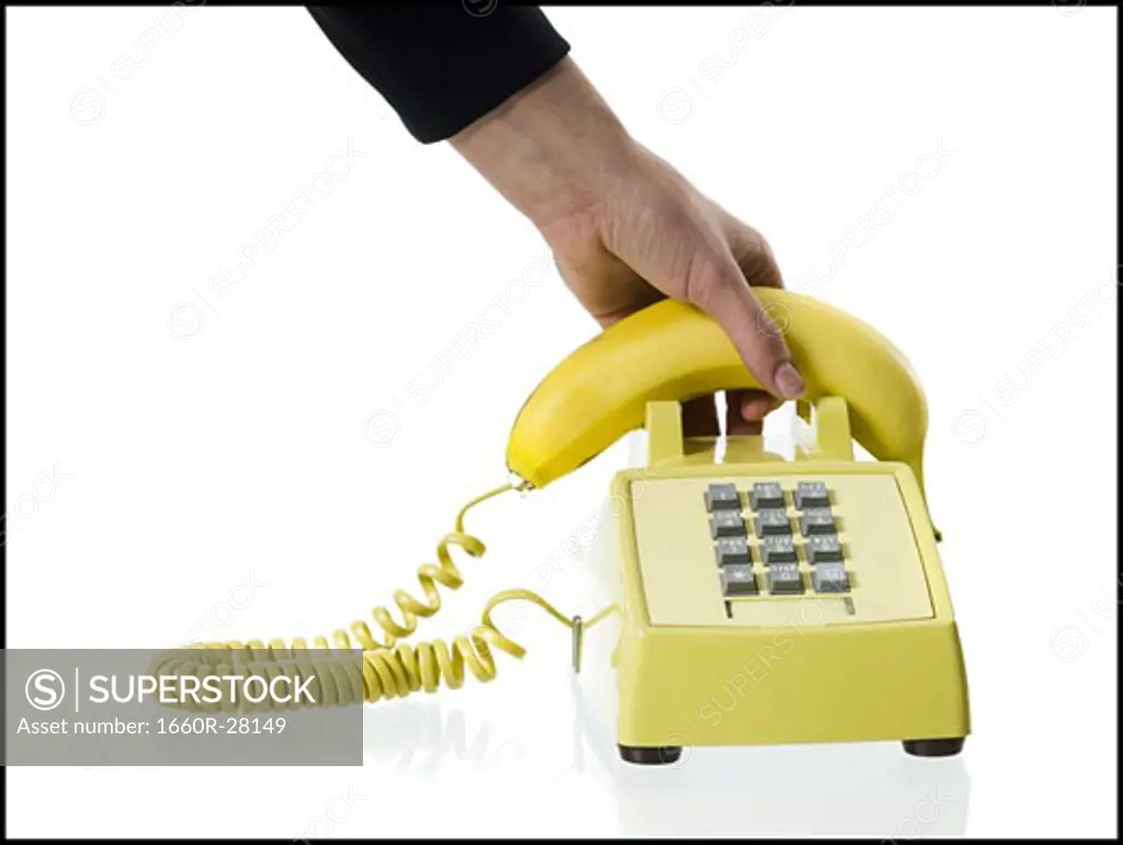 Close-up of a person's hand picking up a banana telephone receiver
