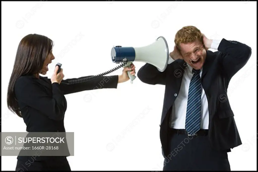 Profile of a teenage girl shouting in a megaphone with a businessman covering his ears