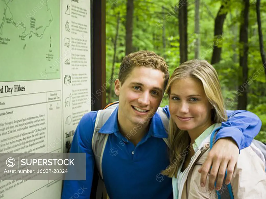 Portrait of a young couple smiling near a map