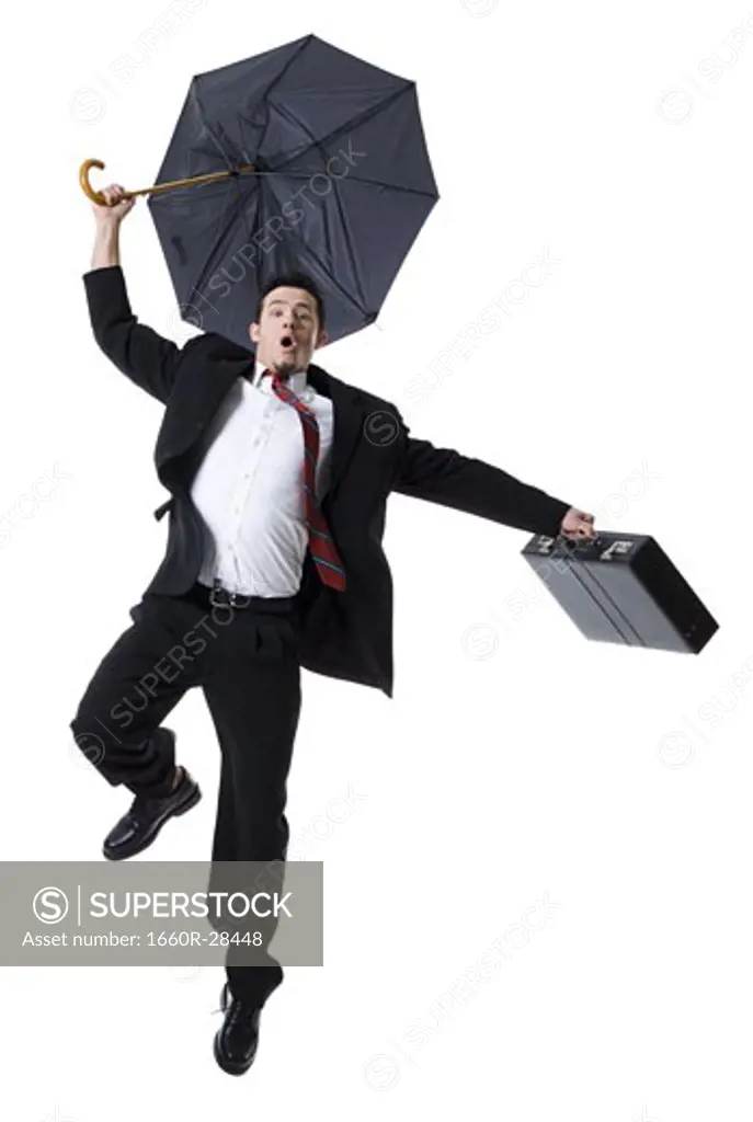 Portrait of a businessman holding an umbrella and jumping