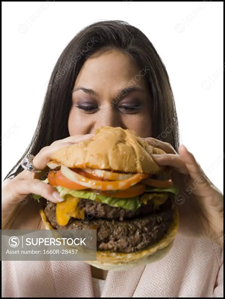 Close-up of a young woman holding a hamburger