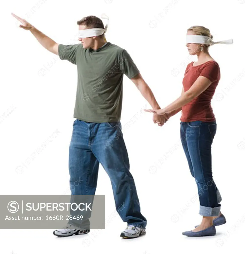 Blindfolded young man leading to a blindfolded young woman