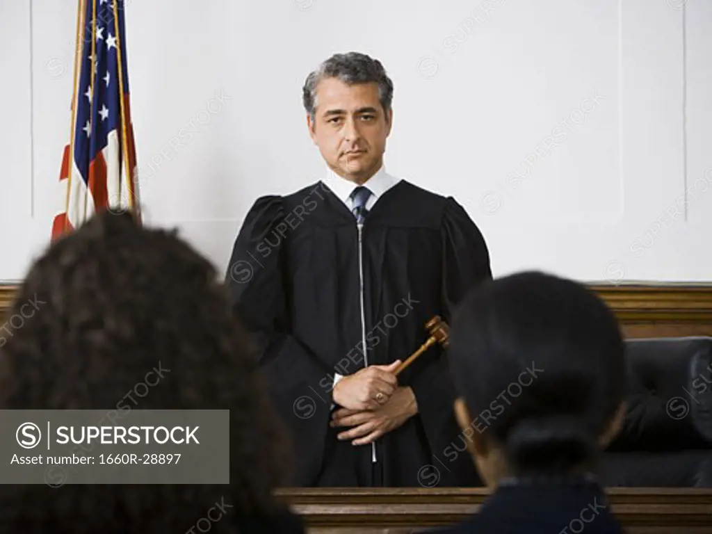 Judge standing in front of defendants and lawyers