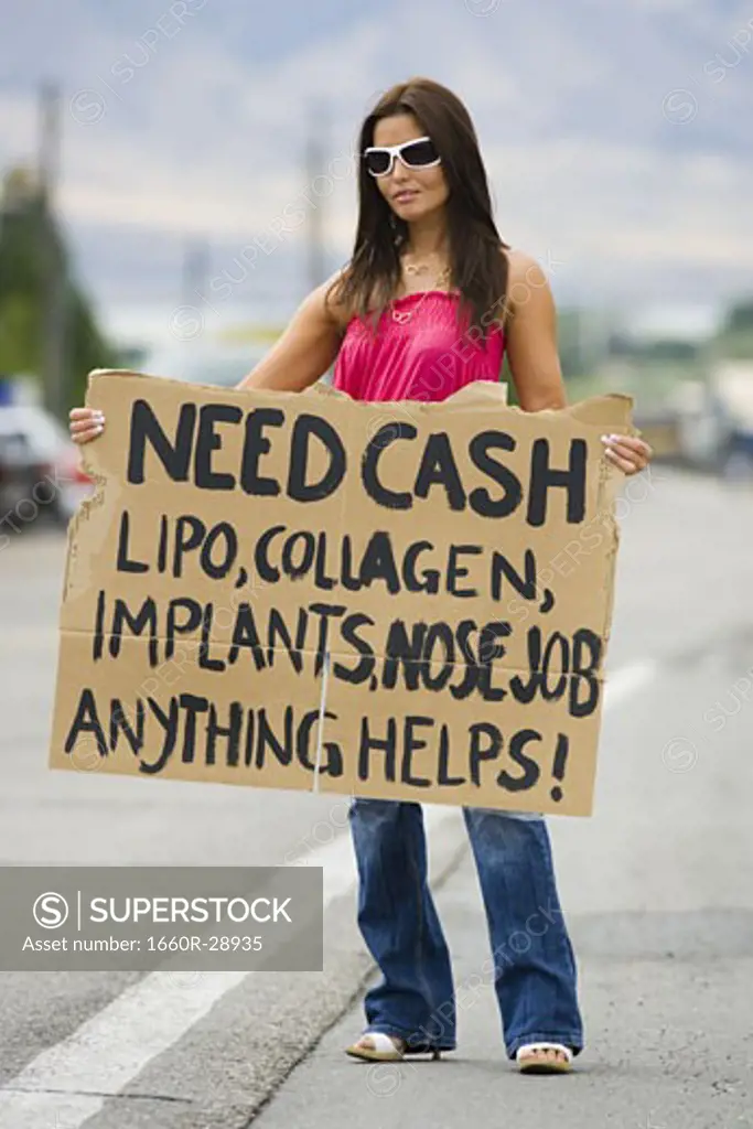 Woman standing on side of road soliciting cash