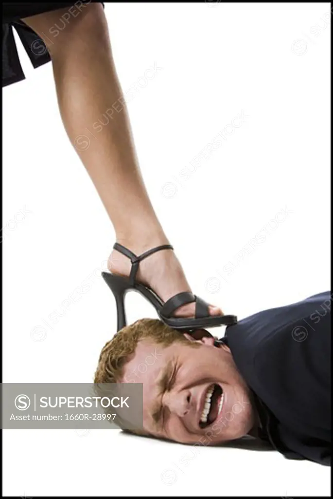 Woman stepping on man's head