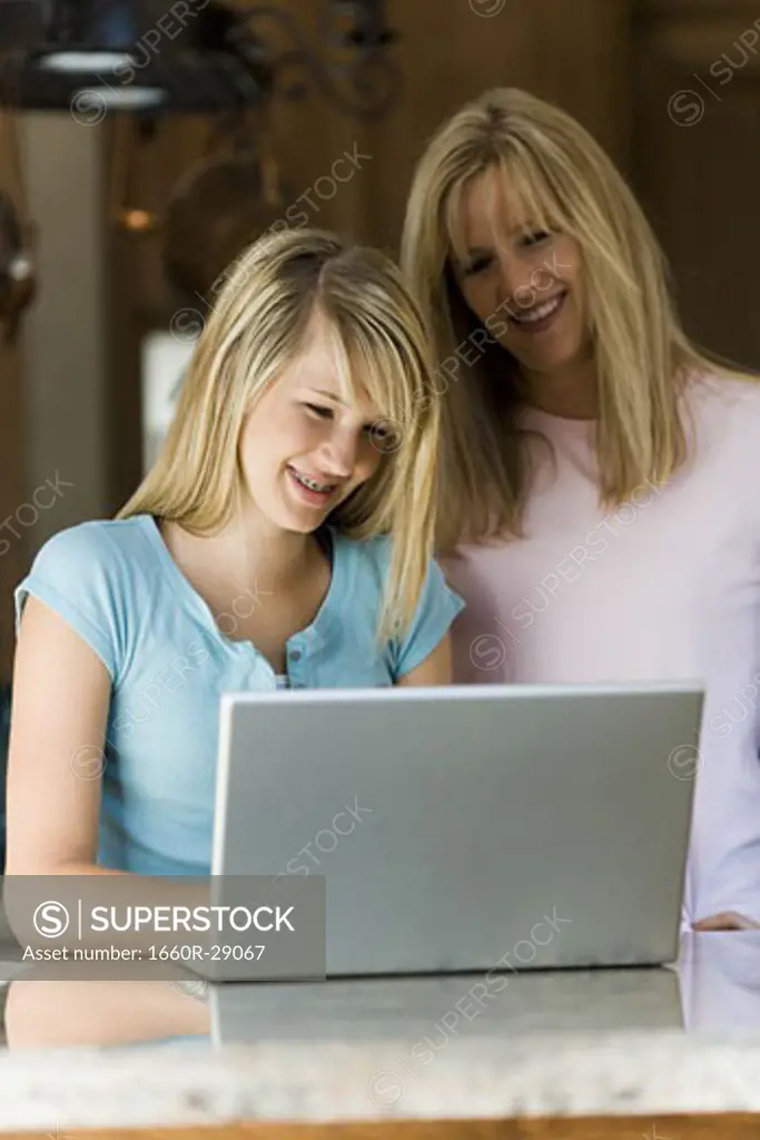 Young woman and mother working on laptop computer
