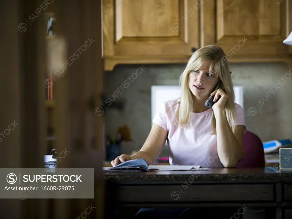 Woman paying bills over telephone