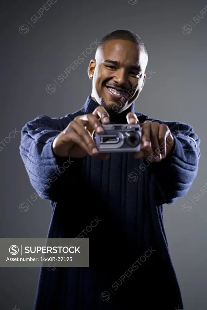 African American man taking picture with digital camera