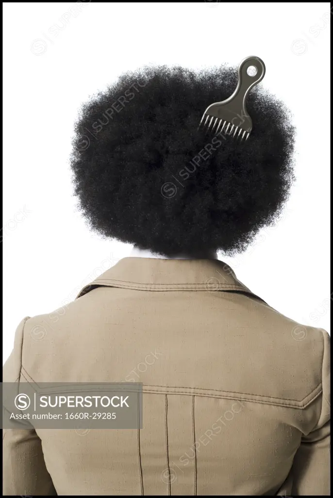 Man with an afro in beige suit with hair pick in hair