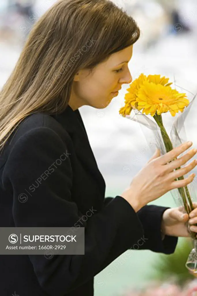 Profile of a young woman smelling a bunch of flowers