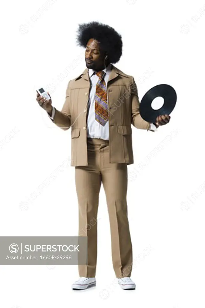 Man with an afro in beige suit listening to MP3 player