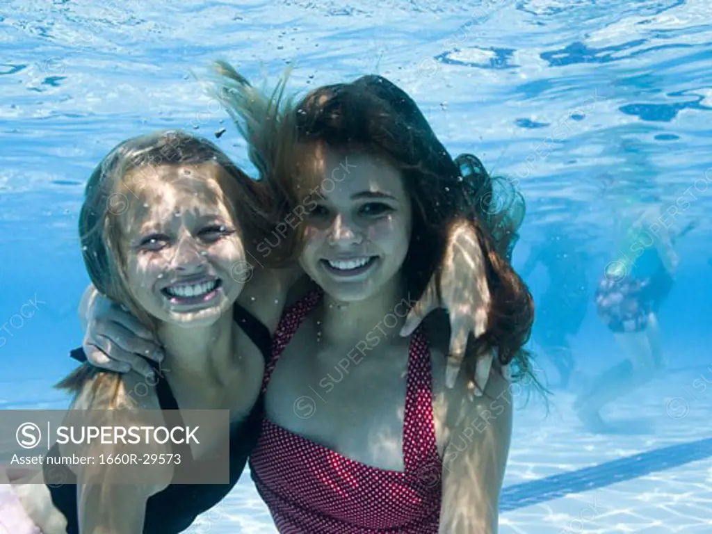 Girls swimming underwater in pool