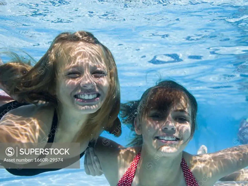 Girls swimming underwater in pool