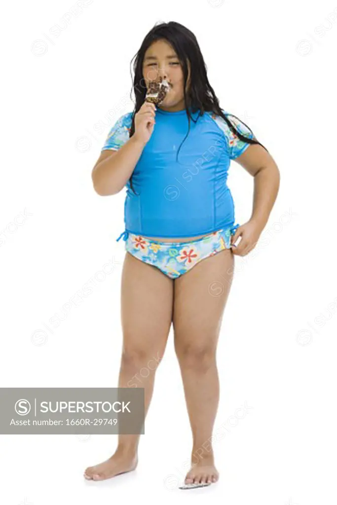 Overweight young girl eating ice cream bar