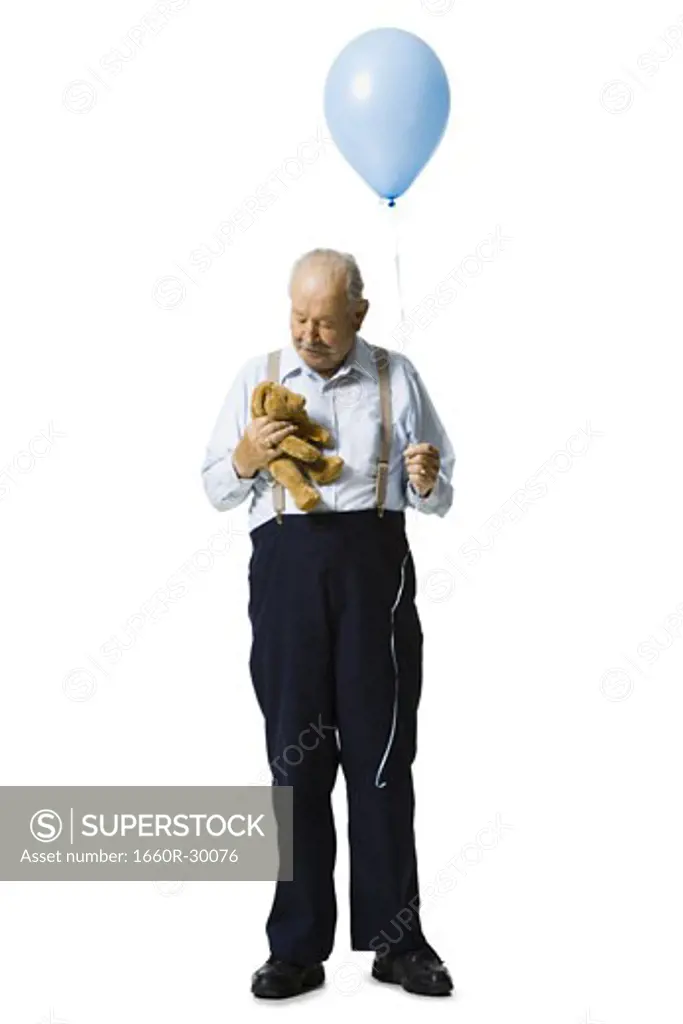 Older man holding balloon and plush toy