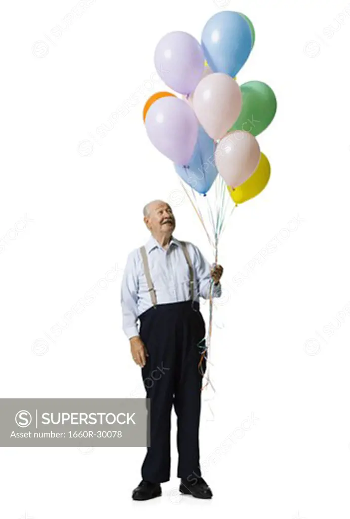 Older man holding balloons