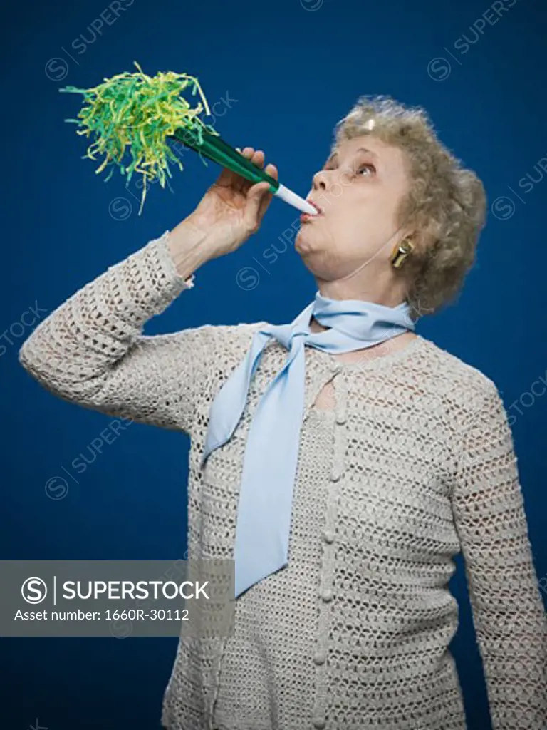 Older woman with noisemaker and party hat