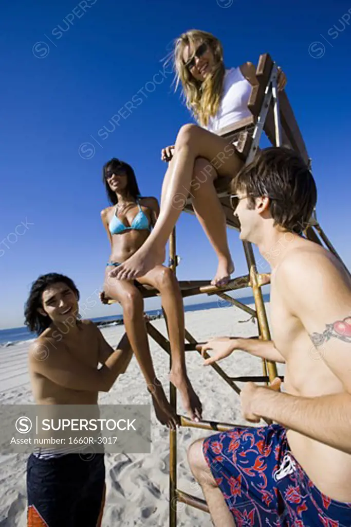 Low angle view of four young people on the beach
