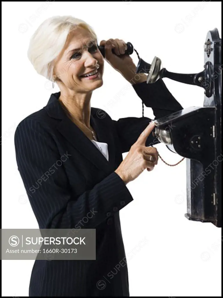 Businesswoman speaking on antique telephone