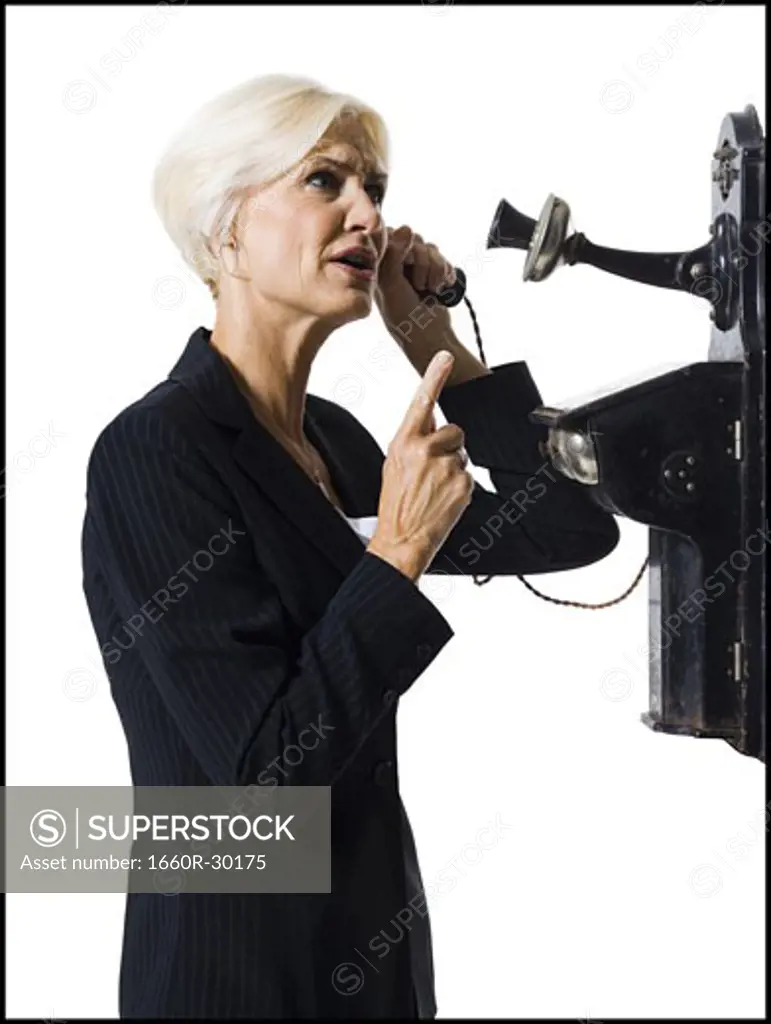 Businesswoman speaking on antique telephone