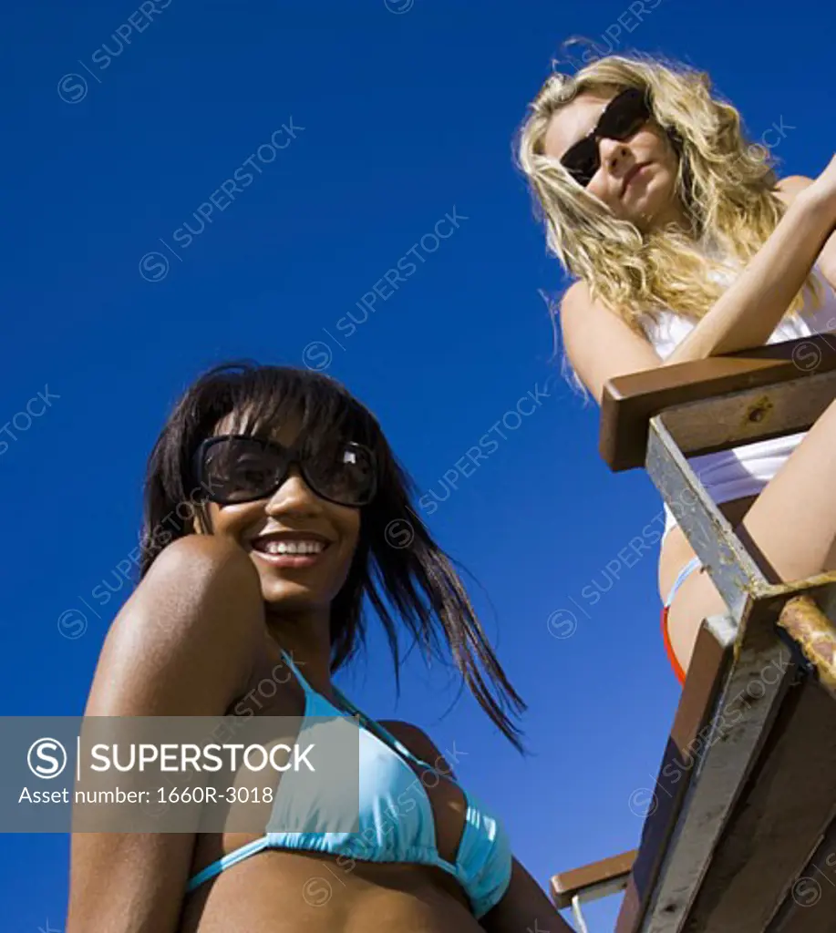 Low angle view of two young women on the beach