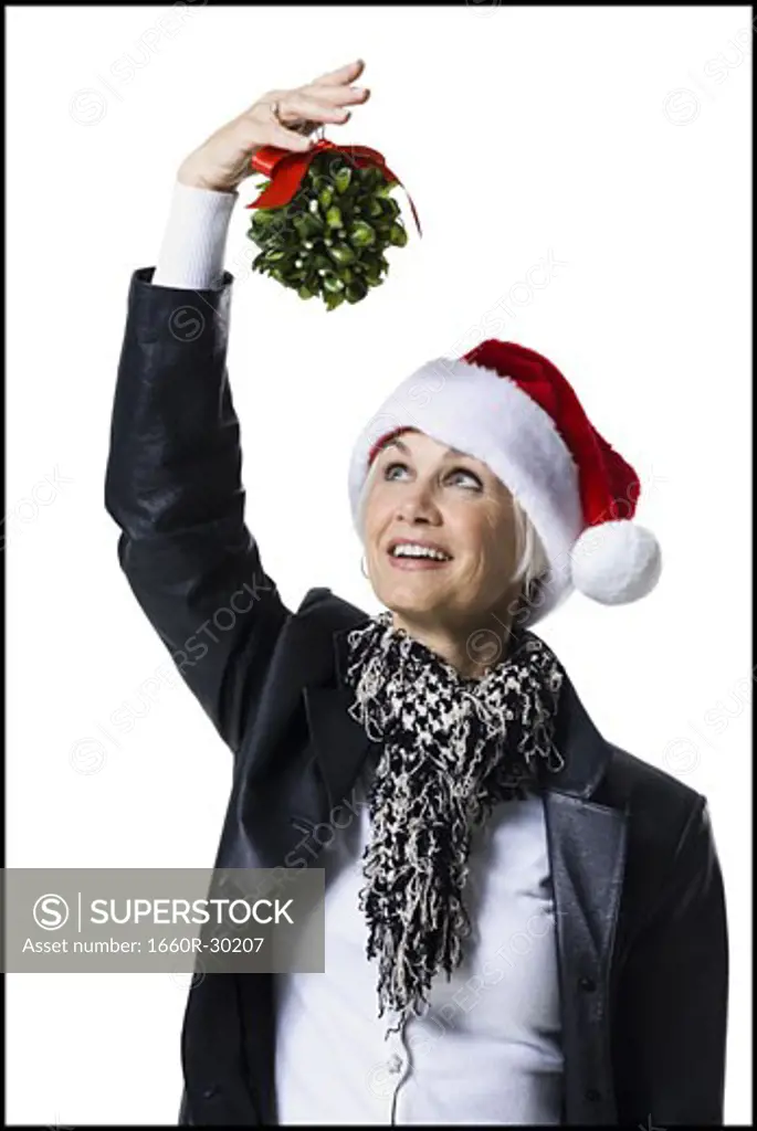 Woman wearing Christmas hat under mistletoe