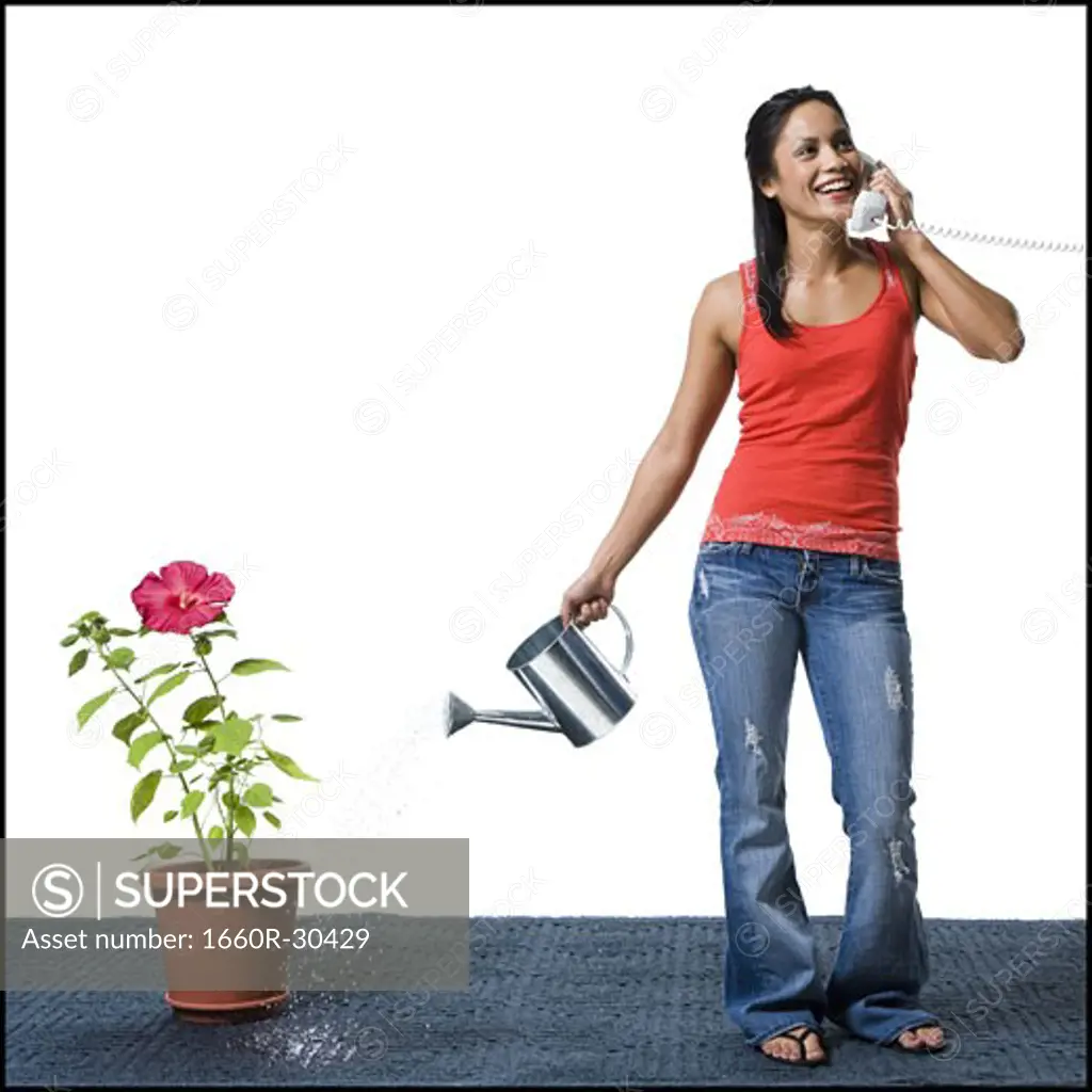 Distracted woman watering flowers but missing the pot