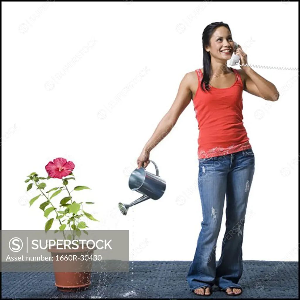 Distracted woman watering flowers but missing the pot