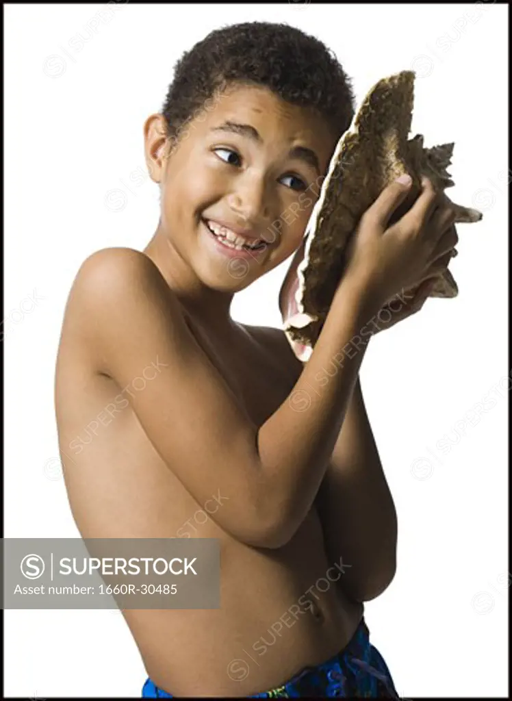 Boy listening to conch shell