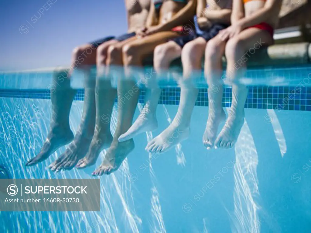 Feet dangling in swimming pool