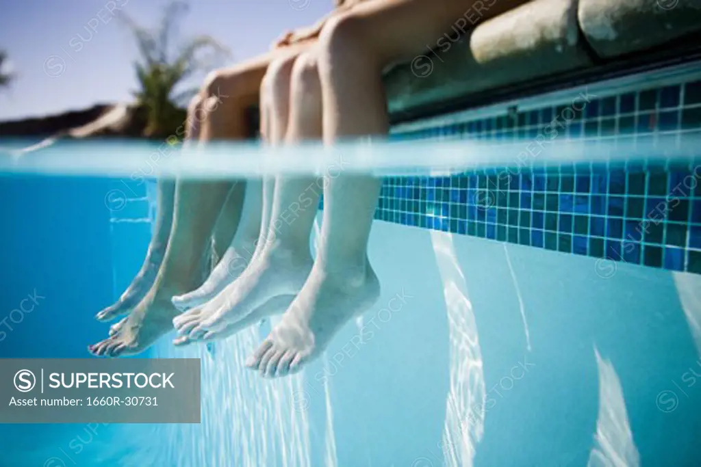 Feet dangling in swimming pool