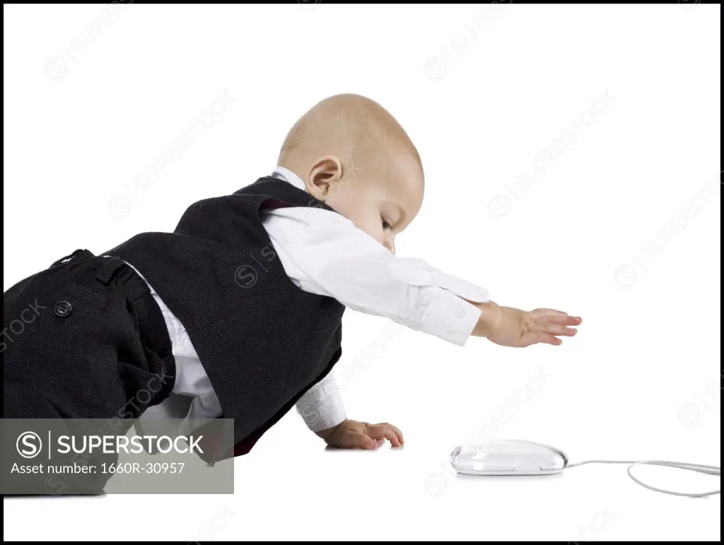Baby Boy in suit crawling to computer mouse