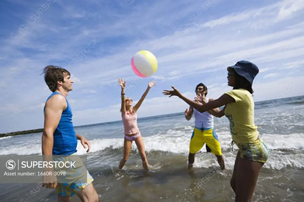 Four young people playing with a beach ball