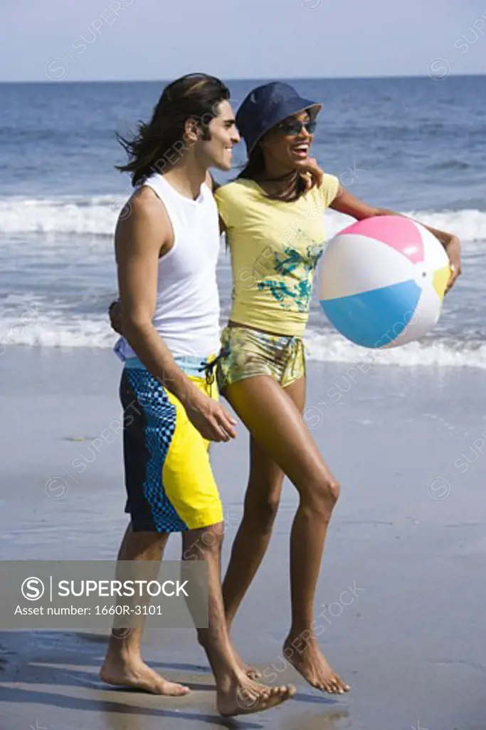 Profile of a young couple walking on the beach