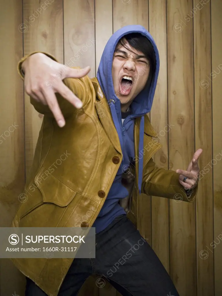 Man with hoodie and leather jacket posing