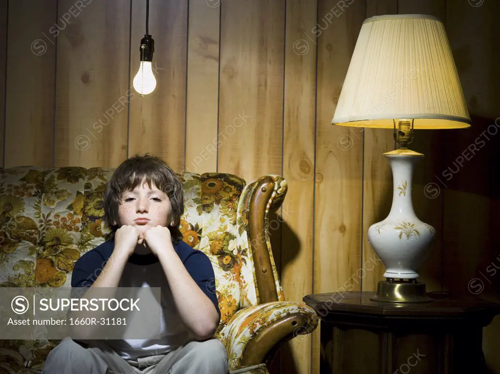 Boy on sofa with light bulb and lamp