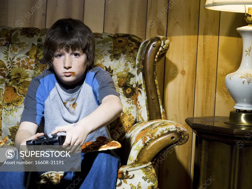 Boy with video game controller on sofa