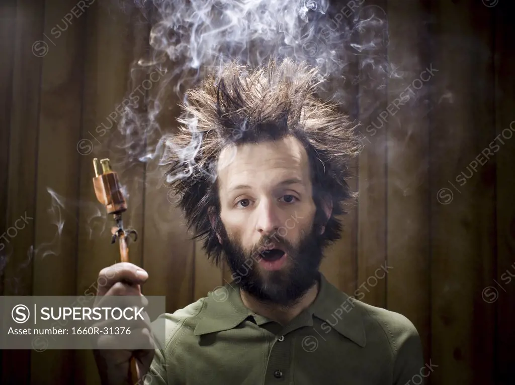 Man after electric shock with electric plug and smoke