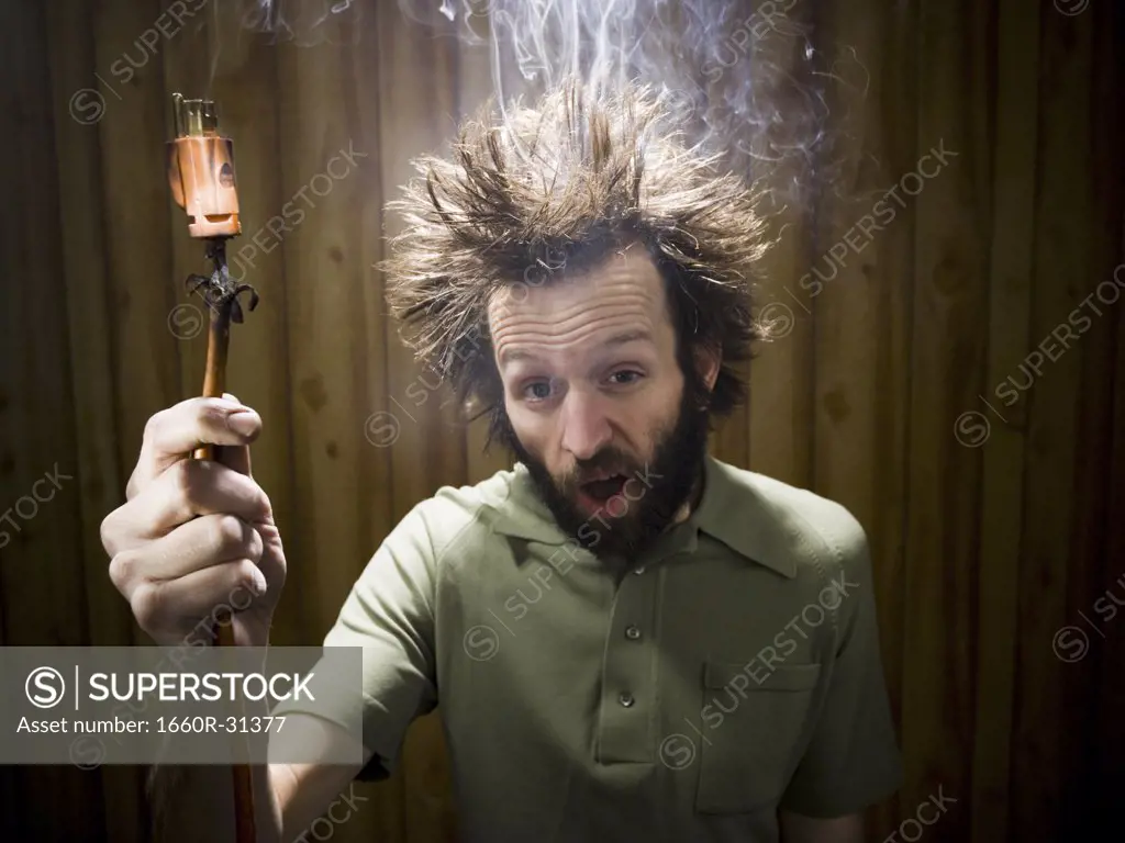 Man after electric shock with electric plug and smoke