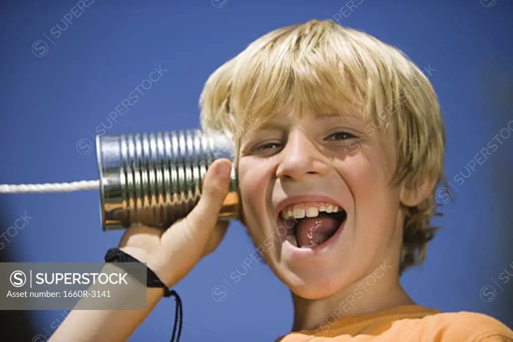 Portrait of a boy using a tin can phone