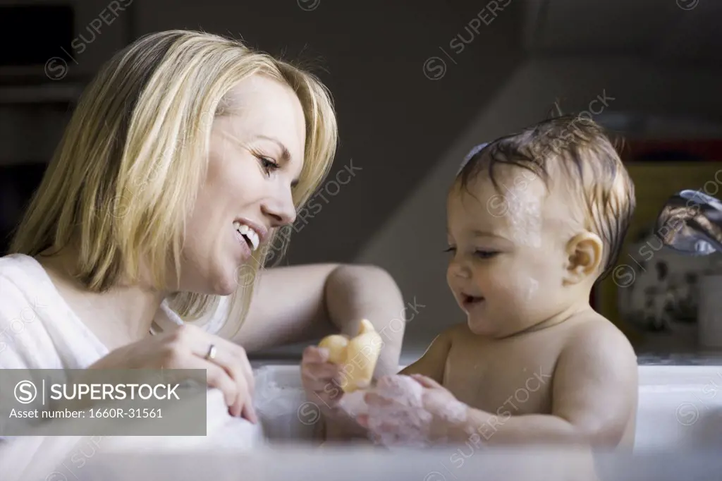 Woman bathing baby in sink