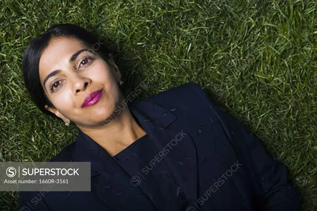 Portrait of a businesswoman lying on a lawn