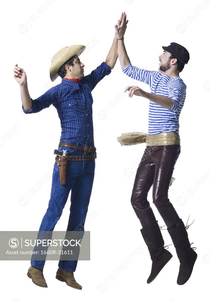 Man in cowboy costume and man in leather pants with waist sash high five