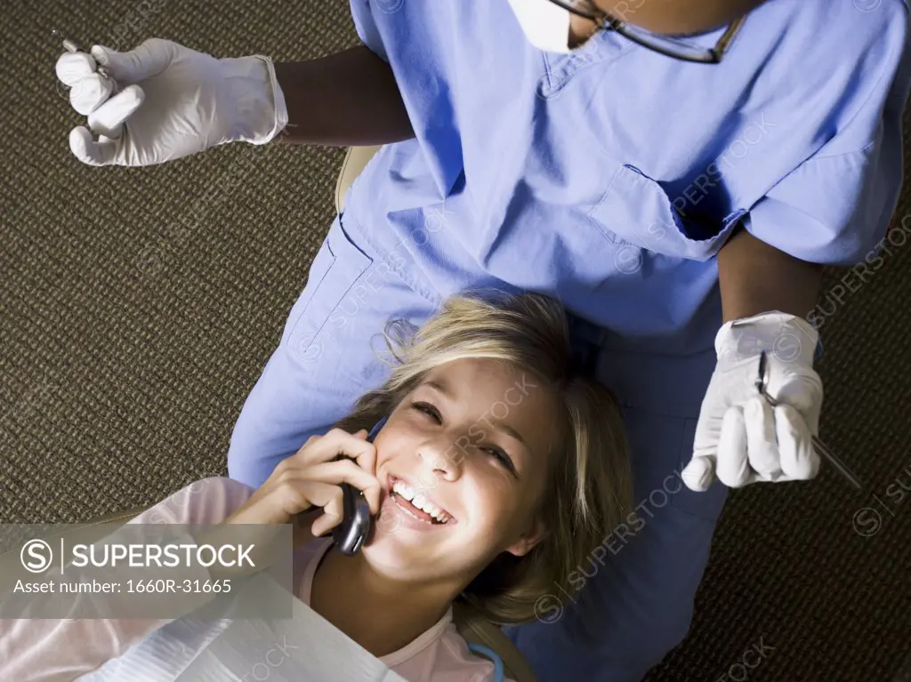 Girl with dental hygienist talking on cell phone