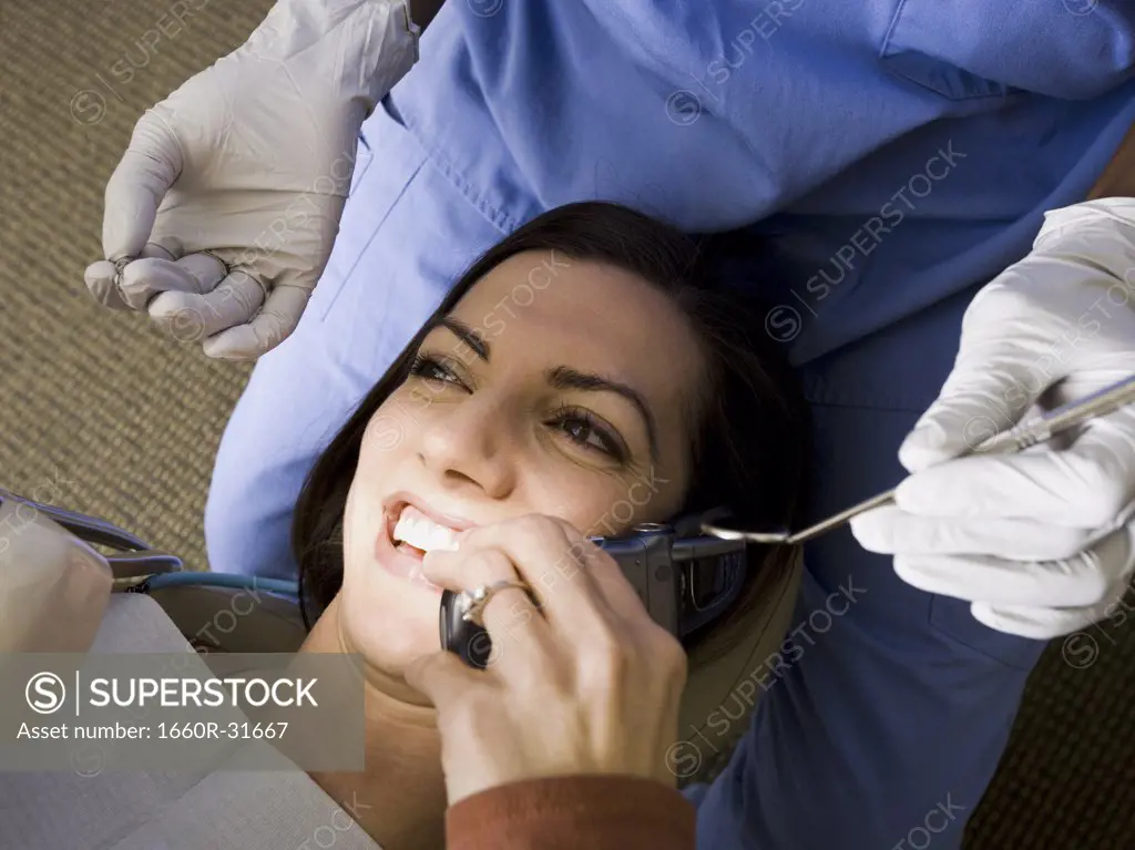 Woman with dental hygienist talking on cell phone